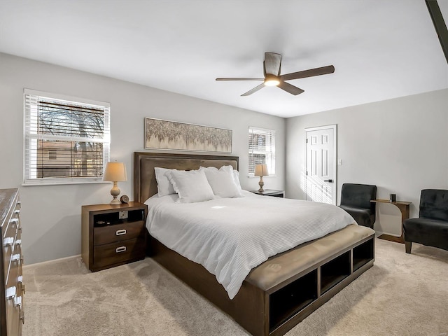 bedroom featuring a closet, baseboards, light colored carpet, and a ceiling fan