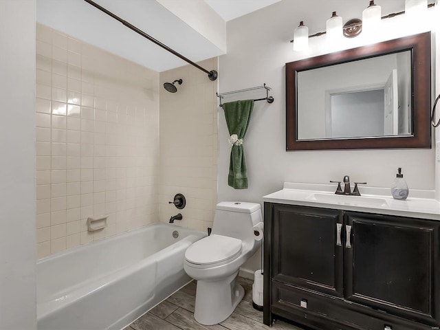 bathroom featuring wood finished floors, toilet, shower / washtub combination, and vanity