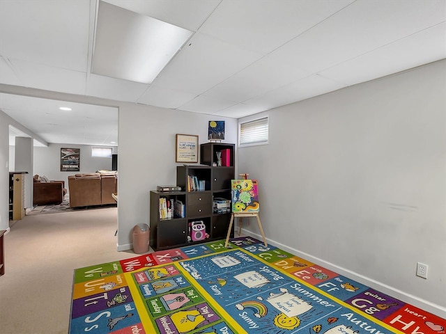 game room with carpet flooring, baseboards, and a drop ceiling