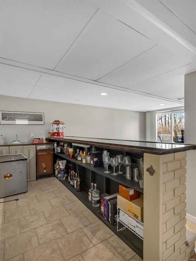 bar with dishwasher, a sink, and stone finish flooring