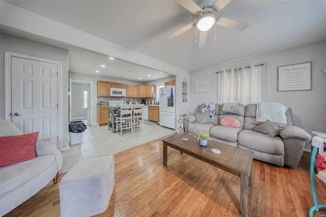 living room featuring ceiling fan and light hardwood / wood-style floors