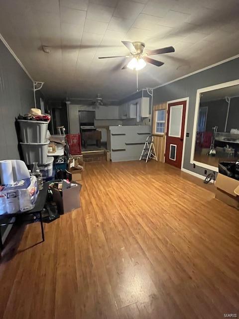 interior space with hardwood / wood-style floors, crown molding, and ceiling fan