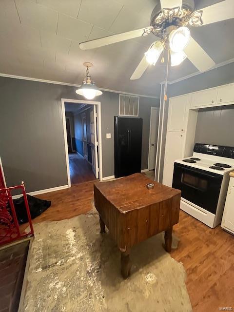 kitchen featuring black fridge, dark hardwood / wood-style flooring, electric range oven, and white cabinets