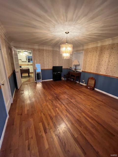 interior space featuring a notable chandelier, hardwood / wood-style flooring, and ornamental molding