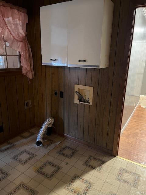 laundry area with washer hookup, cabinets, and wood walls