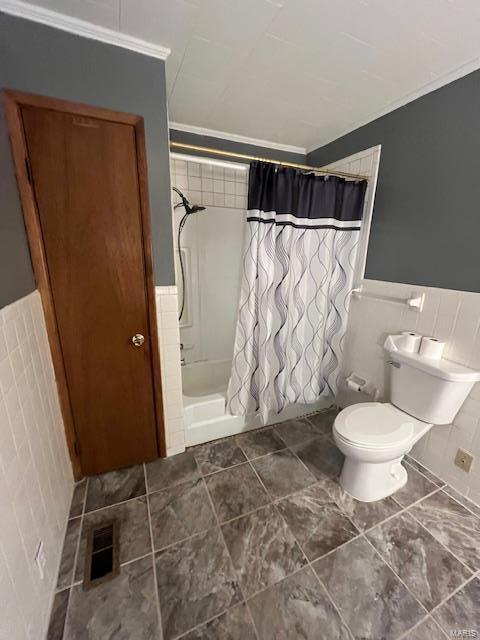 bathroom with toilet, tile walls, and a shower with curtain