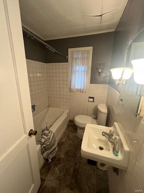 full bathroom with shower / washtub combination, sink, tile walls, and toilet