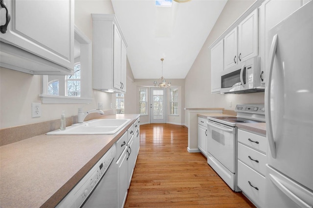 kitchen featuring pendant lighting, white appliances, light countertops, and white cabinetry