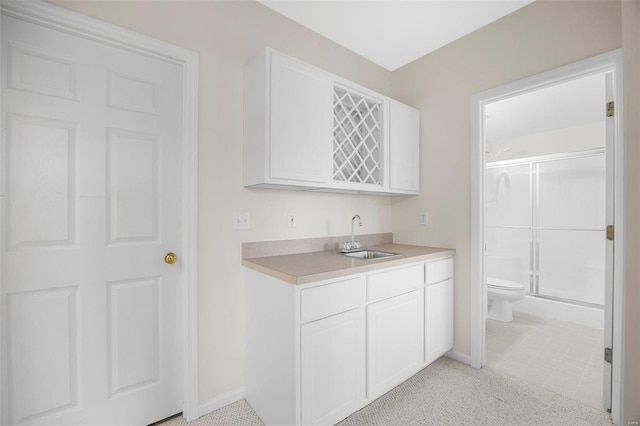 interior space featuring toilet, a shower stall, vanity, and baseboards