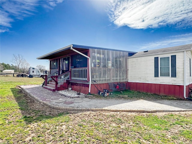 manufactured / mobile home with a front yard and a sunroom