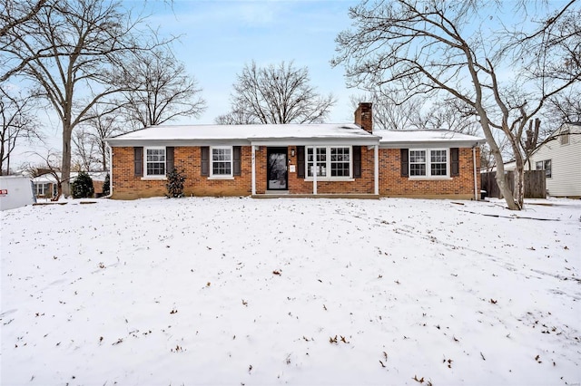 single story home with brick siding and a chimney