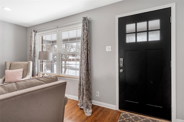 entryway with baseboards and wood finished floors