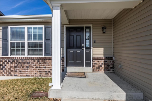 view of exterior entry featuring brick siding