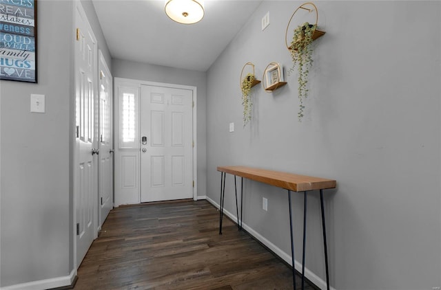 doorway featuring dark wood-style flooring and baseboards