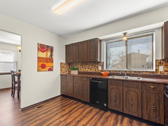 kitchen with dark wood-type flooring, a sink, dark countertops, dark brown cabinets, and dishwasher