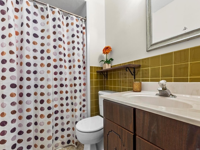 full bathroom featuring toilet, curtained shower, tile walls, wainscoting, and vanity