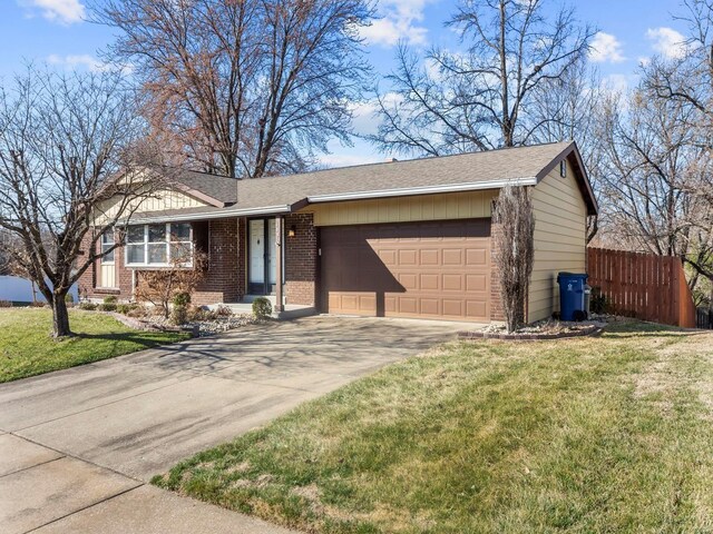 ranch-style house featuring brick siding, a front yard, a garage, and fence