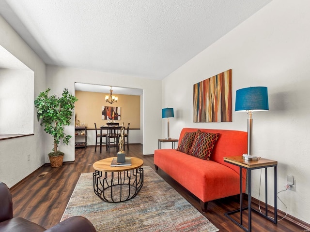 living area with a notable chandelier, wood finished floors, and a textured ceiling