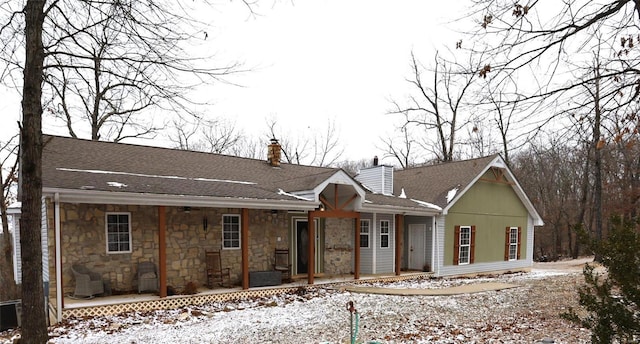 view of front of home with stone siding and a chimney