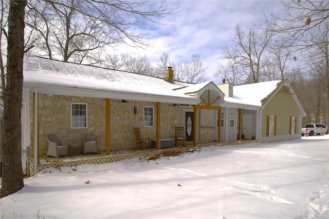 view of front facade with stone siding and a chimney