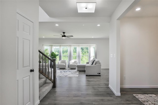 living room with dark hardwood / wood-style flooring and ceiling fan