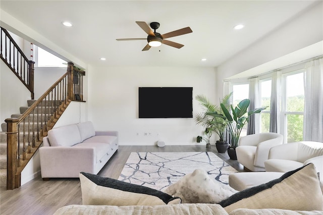 living room featuring ceiling fan and light hardwood / wood-style flooring