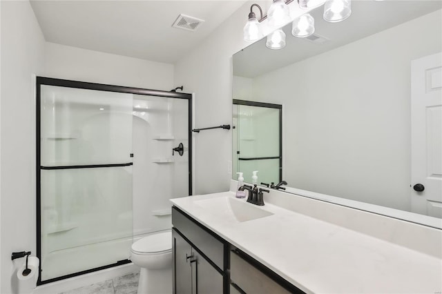 bathroom featuring vanity, a shower with shower door, and toilet