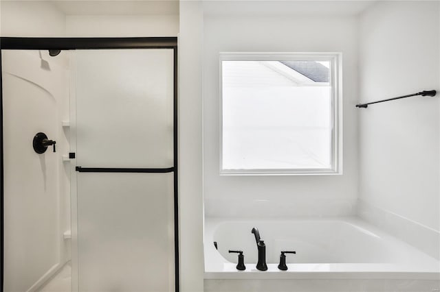 bathroom featuring plus walk in shower and a wealth of natural light