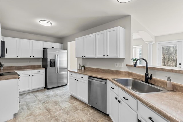 kitchen with a sink, stainless steel appliances, and white cabinets