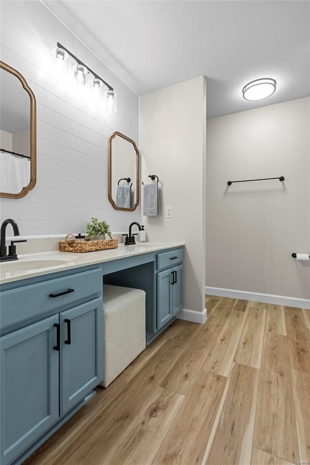 full bath featuring vanity, wood finished floors, and baseboards