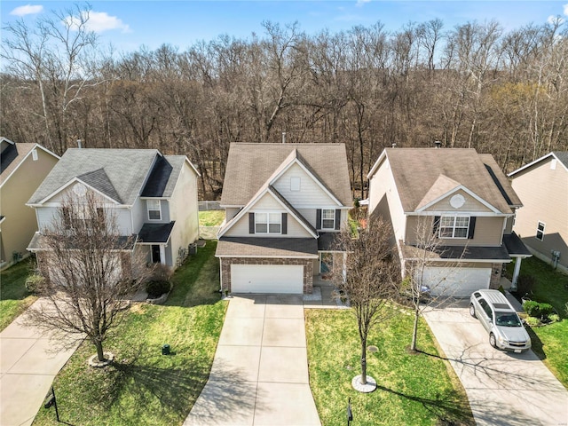 view of front of home with a front yard, brick siding, a garage, and driveway