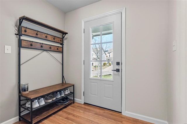 doorway to outside featuring baseboards and light wood finished floors