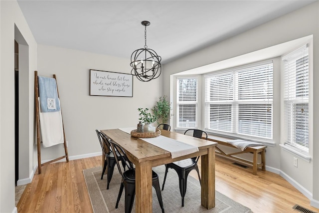 dining room featuring visible vents, baseboards, an inviting chandelier, and light wood-style flooring