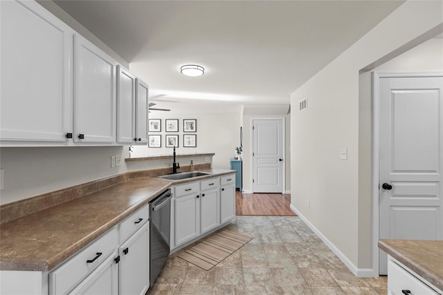 kitchen featuring visible vents, baseboards, dishwasher, white cabinets, and a sink