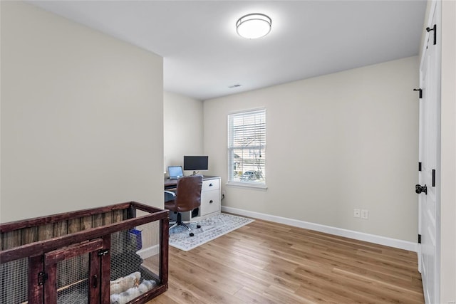 office featuring visible vents, baseboards, and light wood-style floors