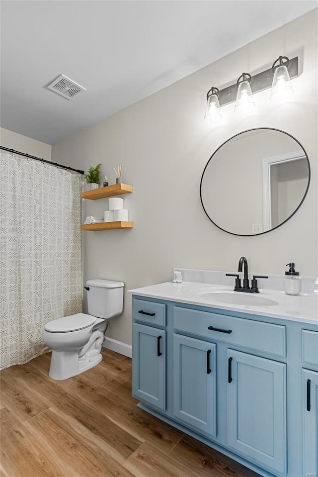 full bathroom featuring vanity, toilet, wood finished floors, and visible vents