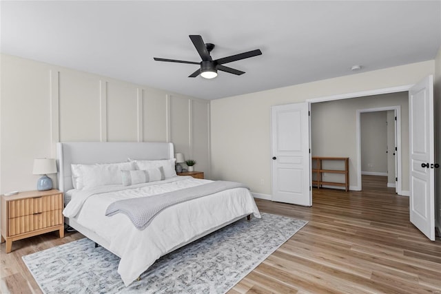 bedroom featuring light wood-style floors, baseboards, and ceiling fan