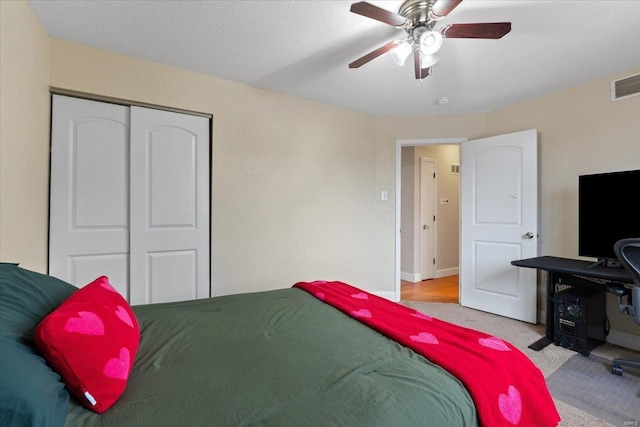 carpeted bedroom with a closet and ceiling fan