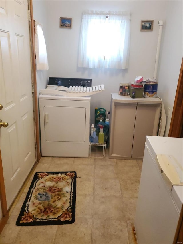 laundry room with washer and dryer and light tile patterned floors