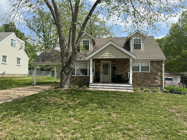 view of front of home with fence, roof with shingles, stone siding, a porch, and driveway