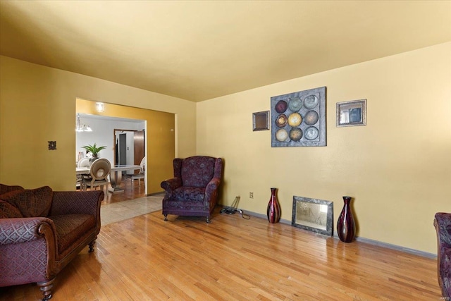 living area with baseboards and wood finished floors