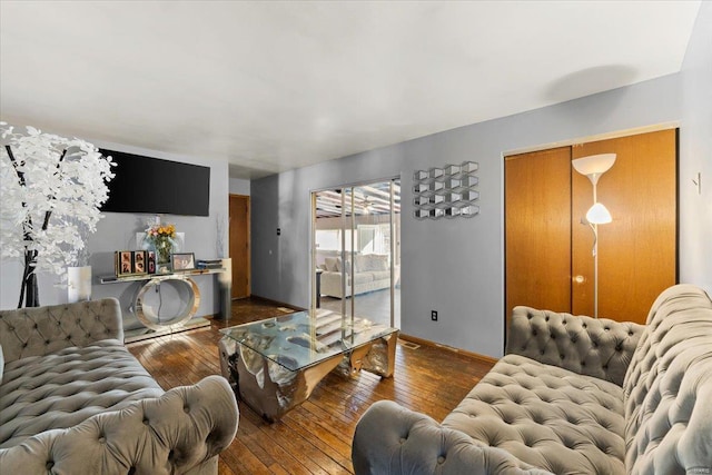 living area featuring baseboards and wood-type flooring