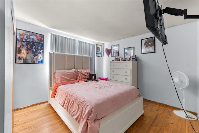 bedroom with baseboards and hardwood / wood-style flooring