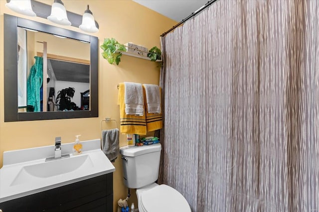 bathroom featuring a shower with shower curtain, toilet, and vanity