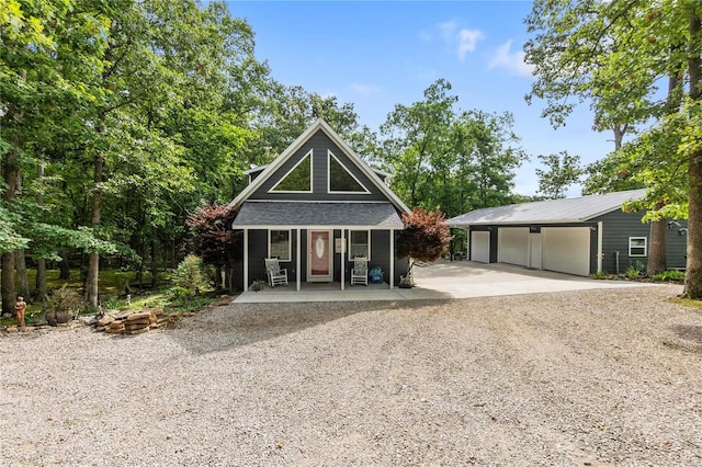 view of front of house featuring a garage, an outdoor structure, and a porch