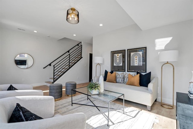 living area with light wood finished floors, baseboards, visible vents, stairway, and recessed lighting