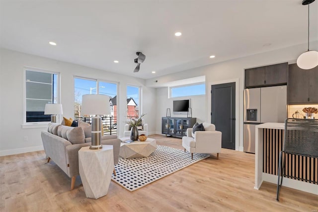 living room with baseboards, recessed lighting, and light wood-style floors