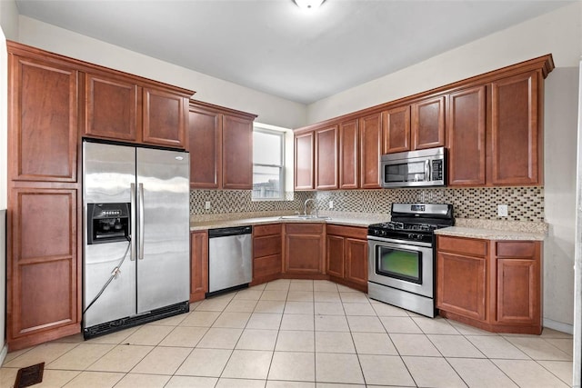 kitchen featuring visible vents, appliances with stainless steel finishes, a sink, light countertops, and backsplash