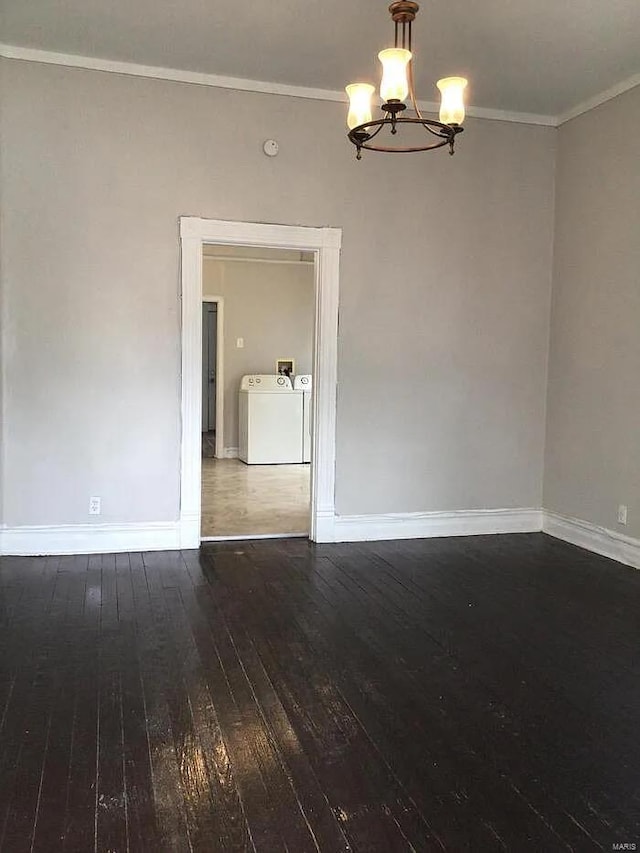 spare room with hardwood / wood-style flooring, crown molding, a chandelier, and washing machine and clothes dryer