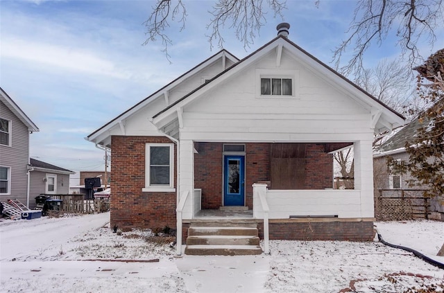 bungalow featuring brick siding